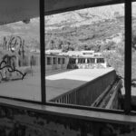 View from inside abandoned building overlooking rooftop courtyard and mountains – nbcreations