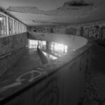 Abandoned building interior with curved ramp and graffiti-covered walls – nbcreations