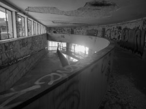 Abandoned building interior with curved ramp and graffiti-covered walls – nbcreations