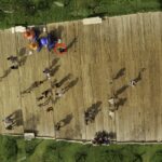 Reflection of people walking on a wooden deck, distorted by a giant mirror – nbcreations