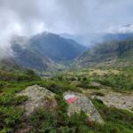 Marked hiking trail on a mossy rock overlooking a misty mountain valley – GR20 Corsica landscape - nbcreations