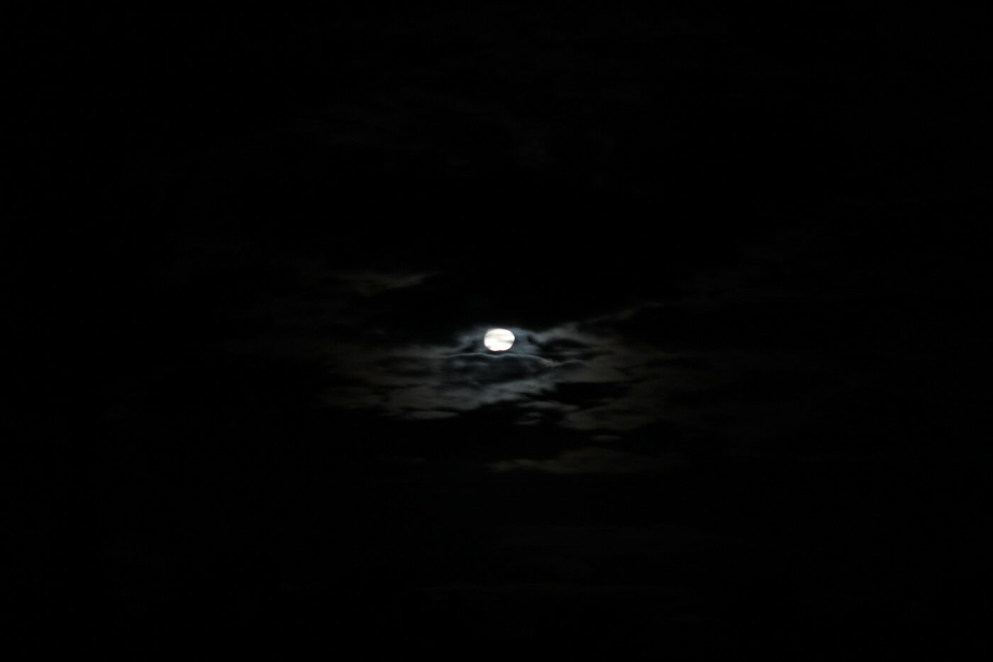 Moonlight breaking through thick clouds on a starless dark night – dramatic lunar sky - nbcreations
