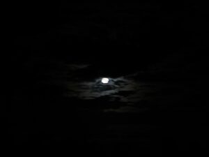Moonlight breaking through thick clouds on a starless dark night – dramatic lunar sky - nbcreations