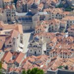 Steep stone staircase descending into Dubrovnik’s old town with terracotta rooftops and stone walls – Croatian historic cityscape - nbcreations