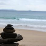 Stone cairn in the foreground with ocean waves in the background – classic seaside composition - nbcreations