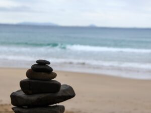 Stone cairn in the foreground with ocean waves in the background – classic seaside composition - nbcreations