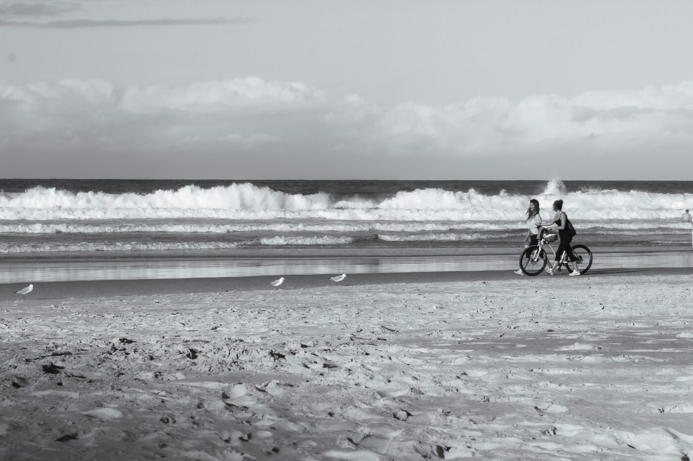 Two girls walking with a bicycle on the beach – relaxed seaside stroll - nbcreations