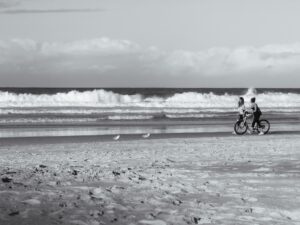 Two girls walking with a bicycle on the beach – relaxed seaside stroll - nbcreations