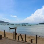 Thai beach with boats floating on the sea – tropical coastline in Thailand - nbcreations