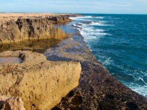 Low two-tiered cliff coastline resembling stone steps, with the sea in the foreground – unique coastal formation - nbcreations