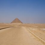 Pathway leading toward an Egyptian pyramid in the desert – ancient monument approach - nbcreations