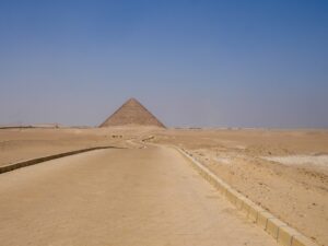 Pathway leading toward an Egyptian pyramid in the desert – ancient monument approach - nbcreations