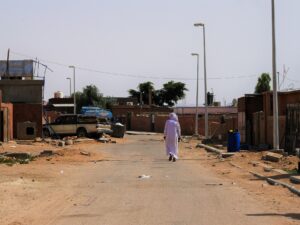 Jordanian village with man in white djellaba walking through the street – Middle Eastern scene - nbcreations