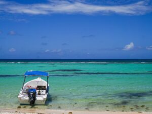 Small boat floating on turquoise water near Santo Domingo – Caribbean seascape - nbcreations