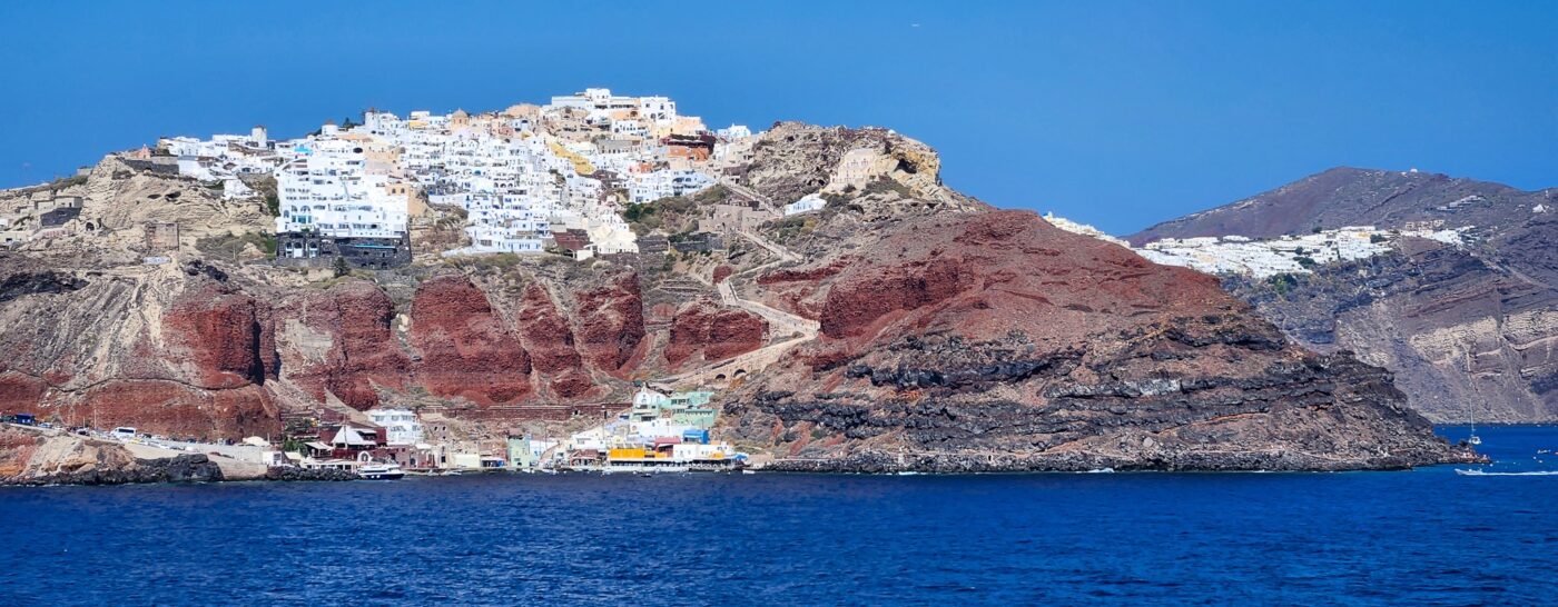 White-washed buildings and blue domes overlooking the sea in Santorini – iconic Greek island view - nbcreations