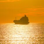 Cargo ship silhouette on golden sea at sunset – nbcreations