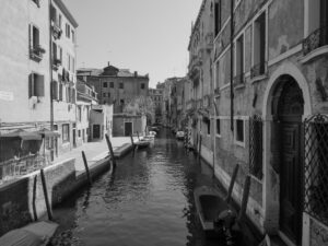 Scenic canal view in Venice with small traditionnal boat– Italian cityscape - nbcreations