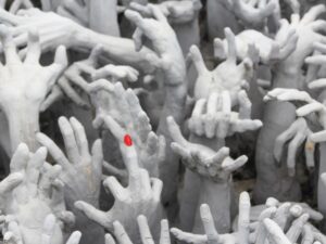 White sculpted hands reaching upward, one with a red fingernail – nbcreations