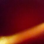 Abstract image with a yellow-orange streak on a dark red background.- nbcreations