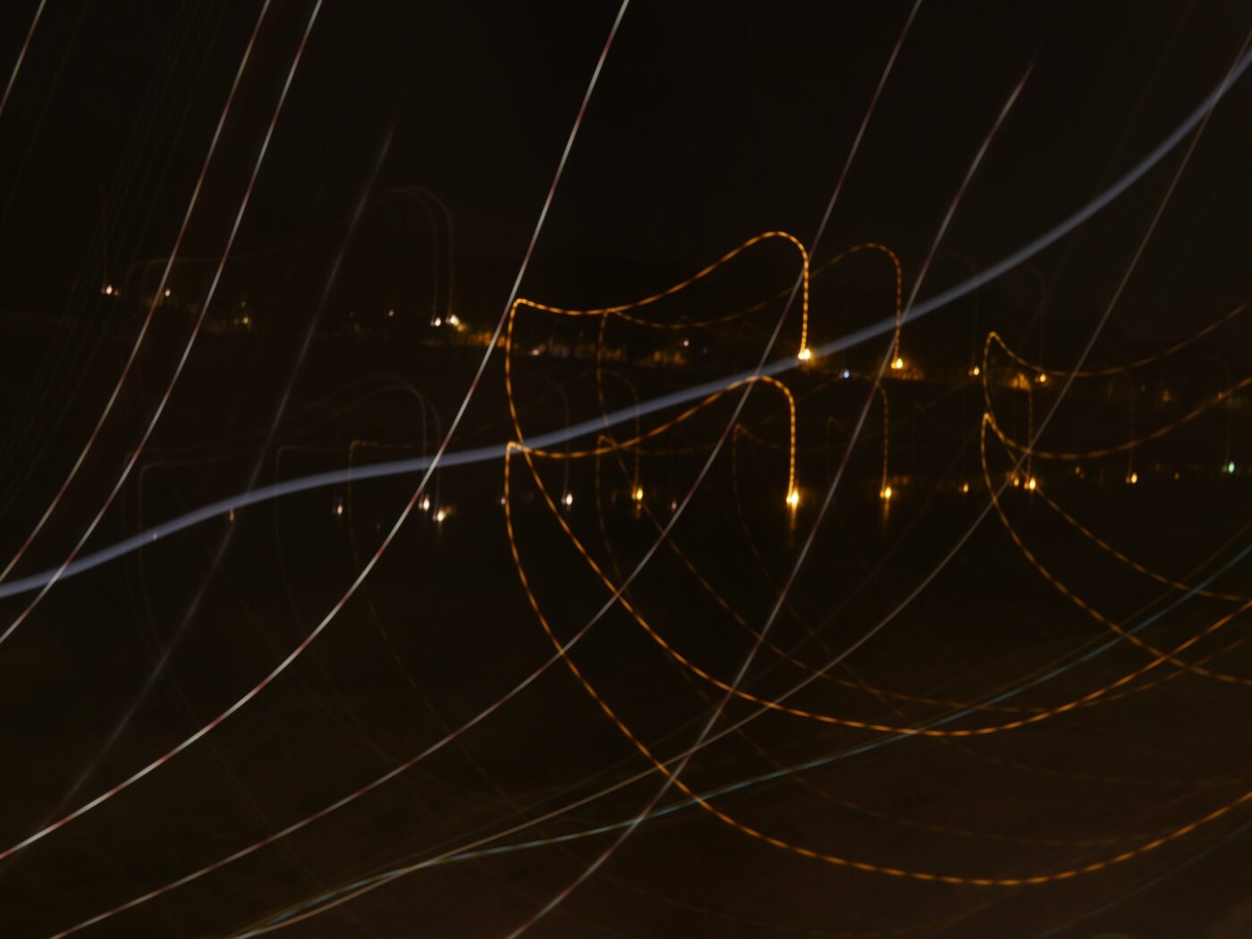 Nighttime light trails with wavy yellow and white lines over city lights – abstract long exposure photography - nbcreations
