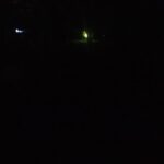 Night scene with faint greenish light glowing in the darkness – minimal and mysterious nocturnal image - nbcreations