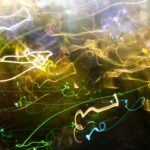 Abstract light painting with green, yellow, and white trails on a dark background.- nbcreations