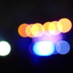 Abstract bokeh lights with blue, orange, and green circles on a black background.- nbcreations