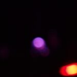 Abstract photo with purple and red blurry lights on a black background.- nbcreations