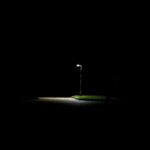 Lit streetlamp surrounded by darkness at night – solitary urban light - nbcreations