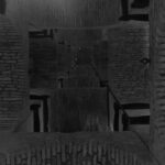 Vertical view inside a tall brick bell tower with repeating arches and beams – nbcreations