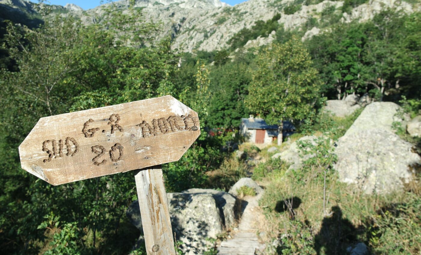 Wooden trail signpost in scenic mountain landscape, GR20 Corsica NBCreations